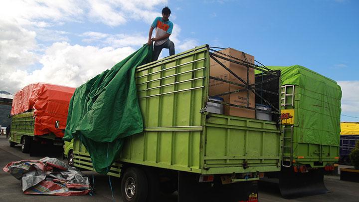 Seorang sopir truk menutup muatannya mengunakan terpal saat antre menyeberang ke Halmahera di Pelabuhan Ferry Bastiong,Ternate, Maluku Utara, Kamis 22 Februari 2024. Para sopir truk lintas Halmahera mengeluhkan pelayanan pelabuhan ferry tidak maksimal sehingga mereka harus mengantre selama dua hari akibat dermaga satu belum difungsikan meskipun sudah selesai diperbaiki akhir tahun lalu dan hanya satu dermaga yang dapat digunakan hingga terhambatnya distribusi logistik ke daerah-daerah. ANTARA FOTO/Andri Saputra