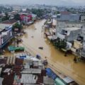 Warga menggunakan perahu melewati genangan banjir di Dayeuhkolot, Kabupaten Bandung, Jawa Barat, Jumat (12/1/2024). (Foto: ANTARA FOTO/NOVRIAN ARBI)